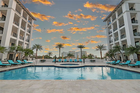 View of a swimming pool surrounded by multi-story residential buildings with balconies.