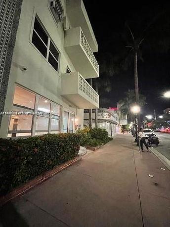 Side view of a multi-story building with balconies at night.