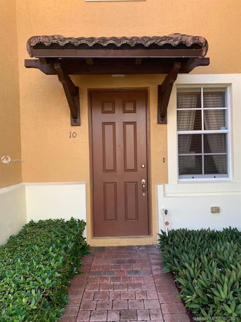 Front view of a house with a brown door and small awning.