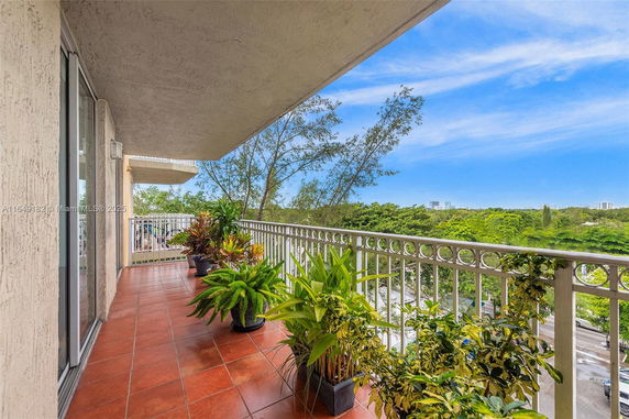Balcony view overlooking greenery and distant buildings.