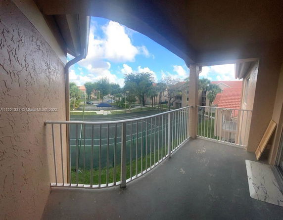 View from a balcony overlooking a neighborhood with houses and trees.