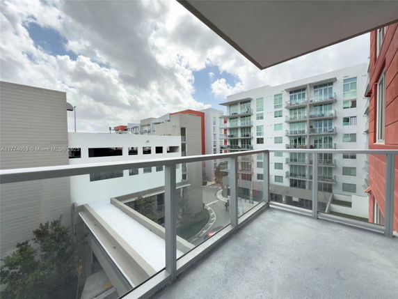 View from a balcony overlooking modern apartment buildings.