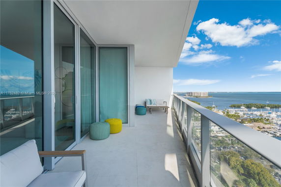 Balcony view with seating area overlooking the ocean and marina.