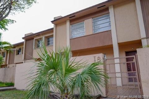 Front view of a two-story residential building with a gated entrance.