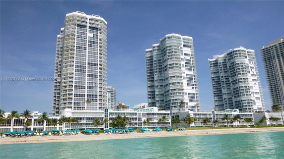 Front view of tall residential buildings by the beach.