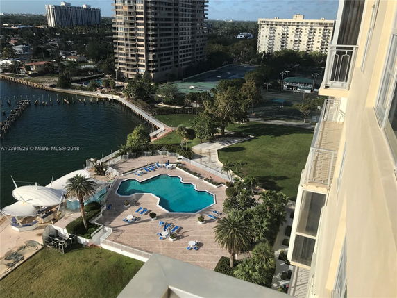 Aerial view from a building showing a swimming pool area and surrounding landscape.