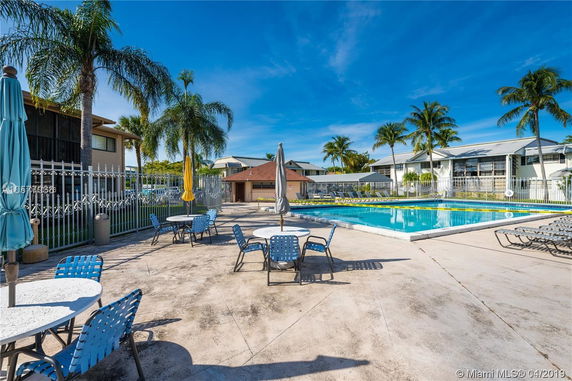 Swimming pool area with surrounding seating and umbrellas.
