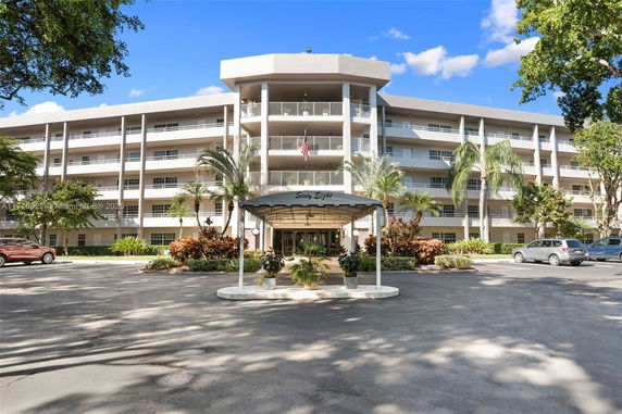 Front view of a multi-story residential building with balconies and a central entrance.