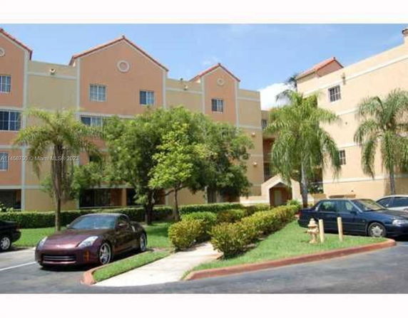 Front view of a multi-story building with a parking area in front.