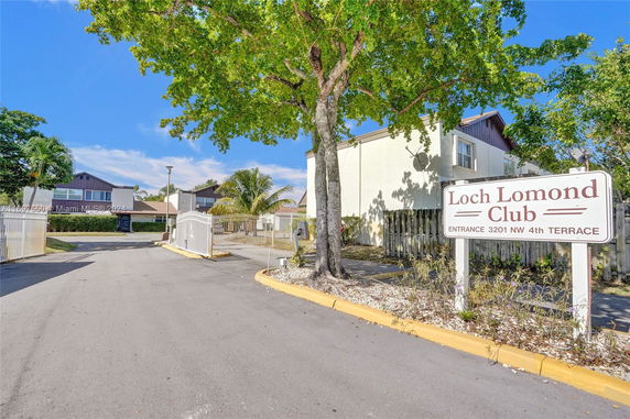 Entrance view of a residential complex with a sign for Loch Lomond Club.