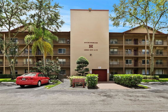Front view of a multi-story apartment building with balconies.