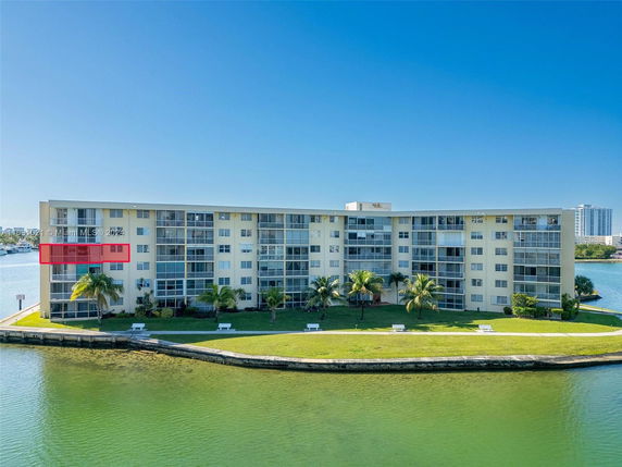 Front view of a multi-story apartment building by the water.