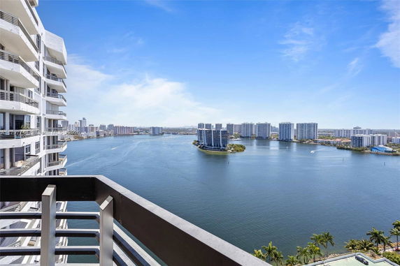 Panoramic view of waterfront with high-rise buildings in the distance.