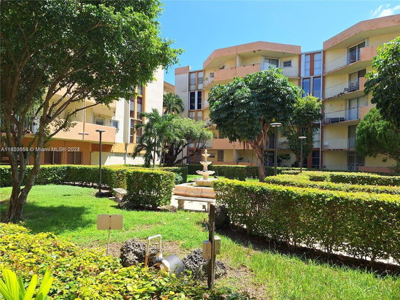 View of multi-story residential buildings with balconies and landscaped gardens.