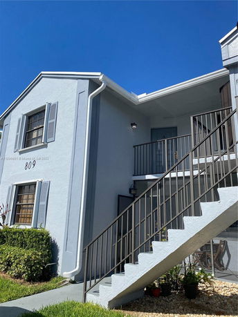 Front view of a two-story residential building with an external staircase.