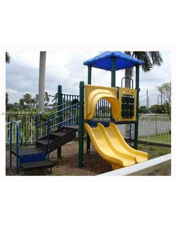 Outdoor playground with a yellow slide and blue-roofed structure.