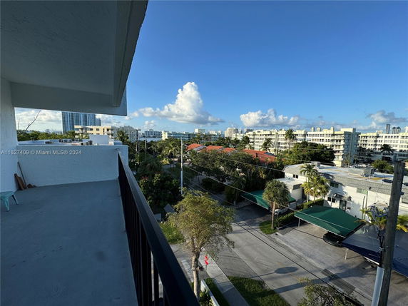 Panoramic view from a balcony showing surrounding residential buildings and streets.