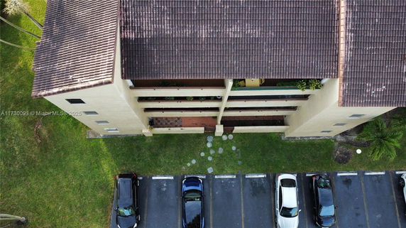 Aerial view of a building with adjacent parking spaces.