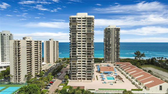 Panoramic view of multiple high-rise buildings along the coastline, with the ocean in the background.