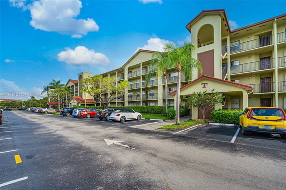 Parking lot in front of a multi-story residential building.