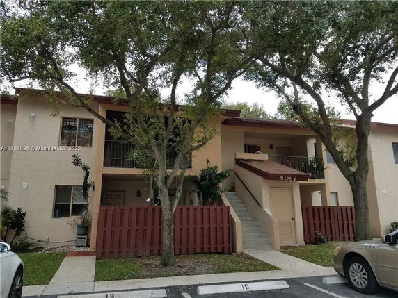 Front view of a two-story residential building with an external staircase.