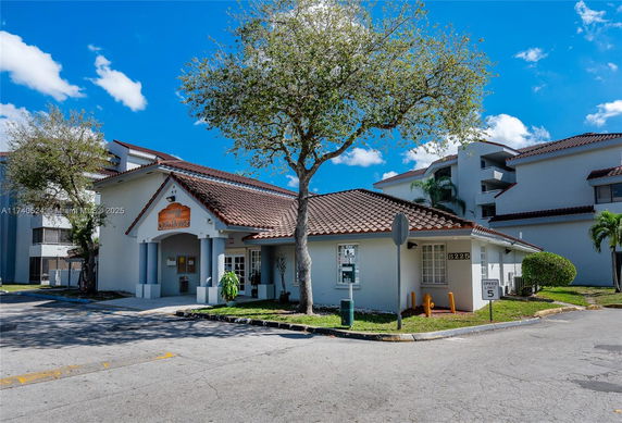 Front view of a building with a tiled roof and sign reading 'Club House'.