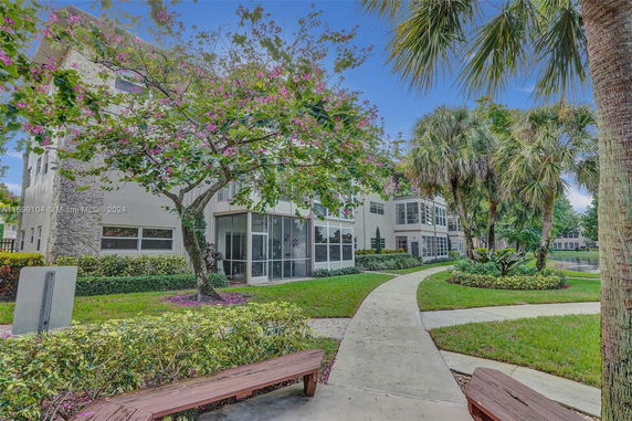 Exterior view of a multi-story building with a pathway and trees.