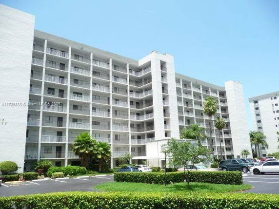 Front view of a multi-story apartment building with balconies.