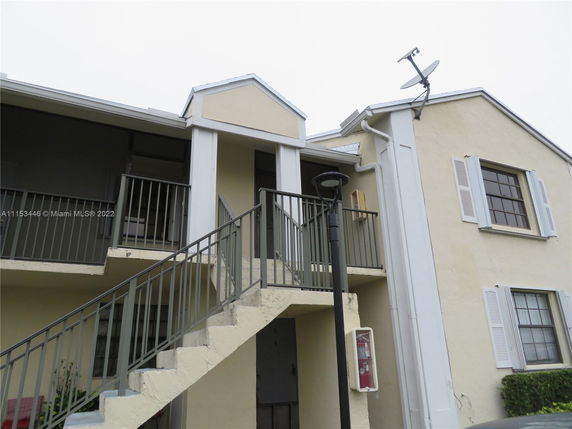 Front view of a two-story building with external stairs.