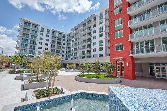 Front view of a modern multi-story apartment complex with balconies.
