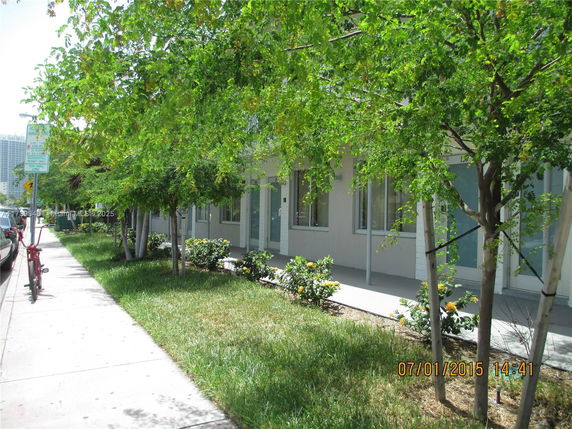 Front view of a building with a row of windows and a sidewalk.