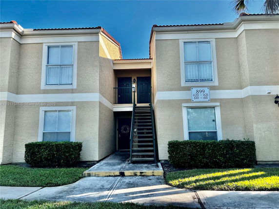Front view of a two-story apartment building with stairway access.