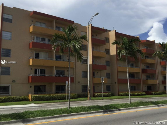 Front view of a multi-story apartment building with balconies.