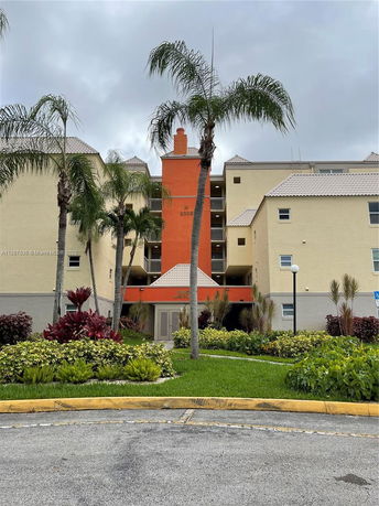 Front view of a multi-story residential building with a distinct orange section and light-colored walls.