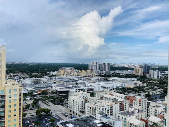 Panoramic view of urban cityscape with multiple buildings and a cloudy sky.