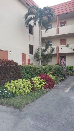 Front view of a multi-story building with a red-tiled roof.