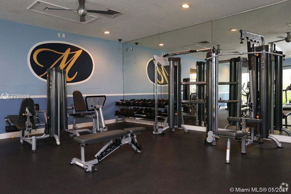Indoor gym area with exercise equipment and mirrors.