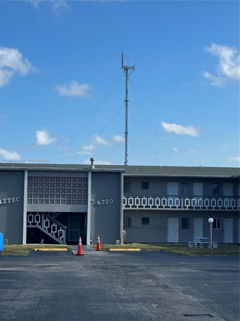 Front view of a two-story building with a visible tower on the rooftop.