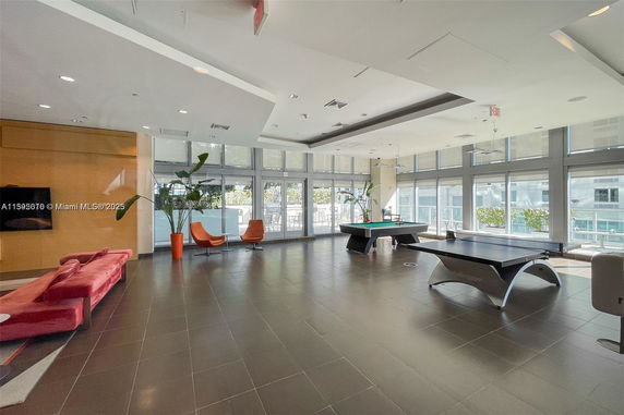 Spacious recreational room with pool table and seating area.
