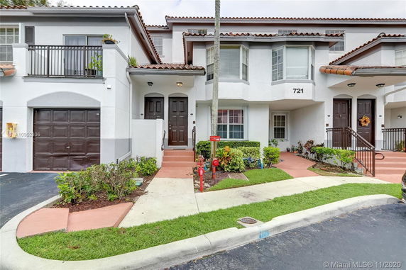 Front view of a townhouse with multiple entrances and a garage.