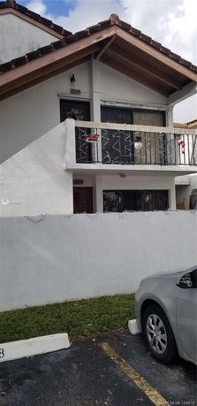 Front view of a two-story residential building with a balcony.