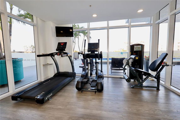 Indoor gym area with exercise equipment and large windows.