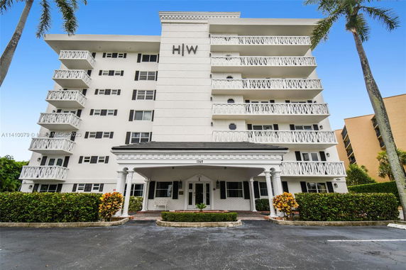 Front view of a multi-story building with balconies and decorative railings.