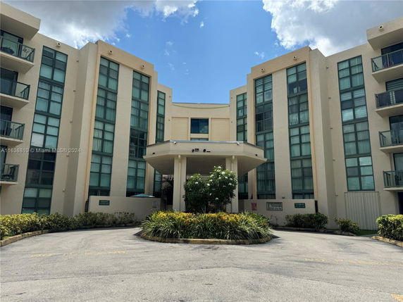 Front view of a multi-story building with large windows and balconies.