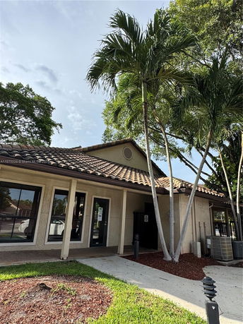 Front view of a single-story building with large windows and a tiled roof.
