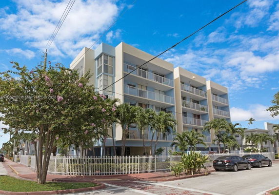 Front view of a multi-story apartment building with balconies.