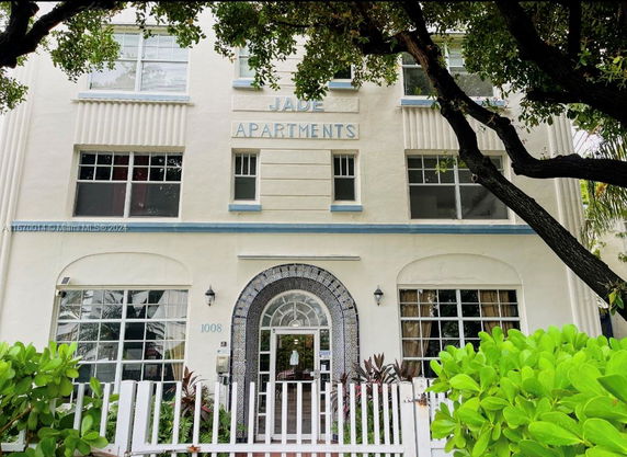 Front view of a multi-story apartment building with a gated entrance.
