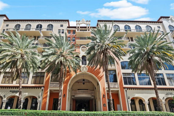 Front view of a multi-story building with palm trees.