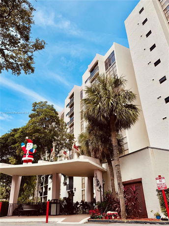 Front view of a multi-story residential building with a decorative Santa Claus figure.
