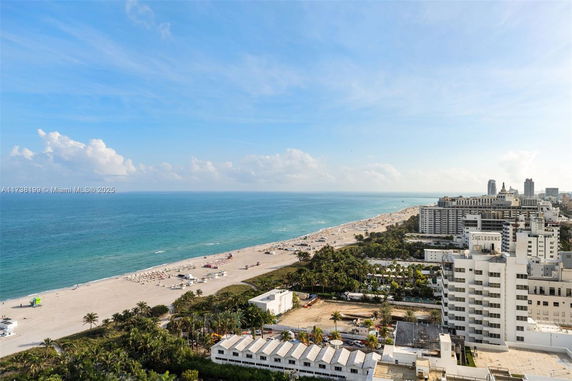 Wide angle view of a coastal cityscape with high-rise buildings and a beach.